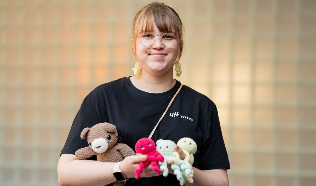 4H-yrittäjällä on sylissään kudottuja eläinhahmoja.