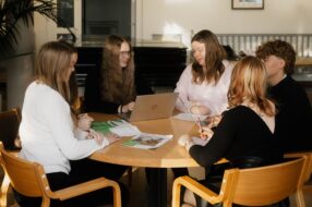 Nuoria kokoontuneena pöydän ääreen.