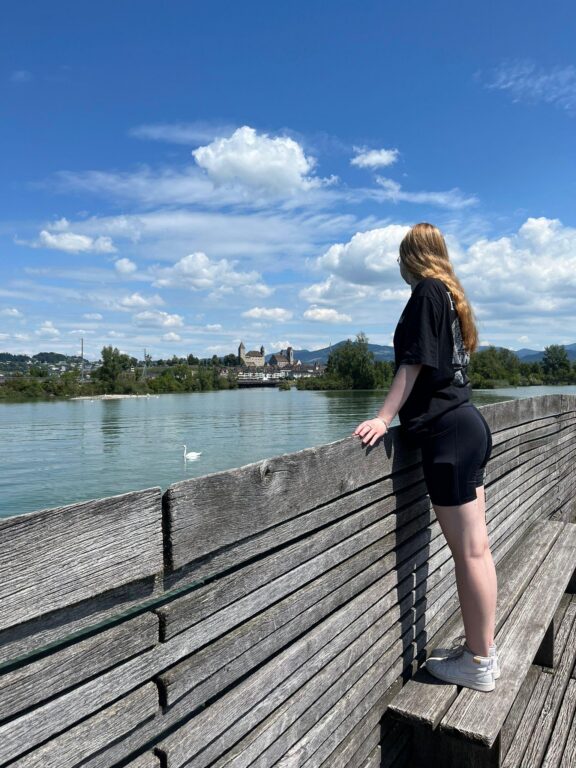 Anni katselemassa vesistöä ja horisontissa näkyvää vanhaa linnaa.