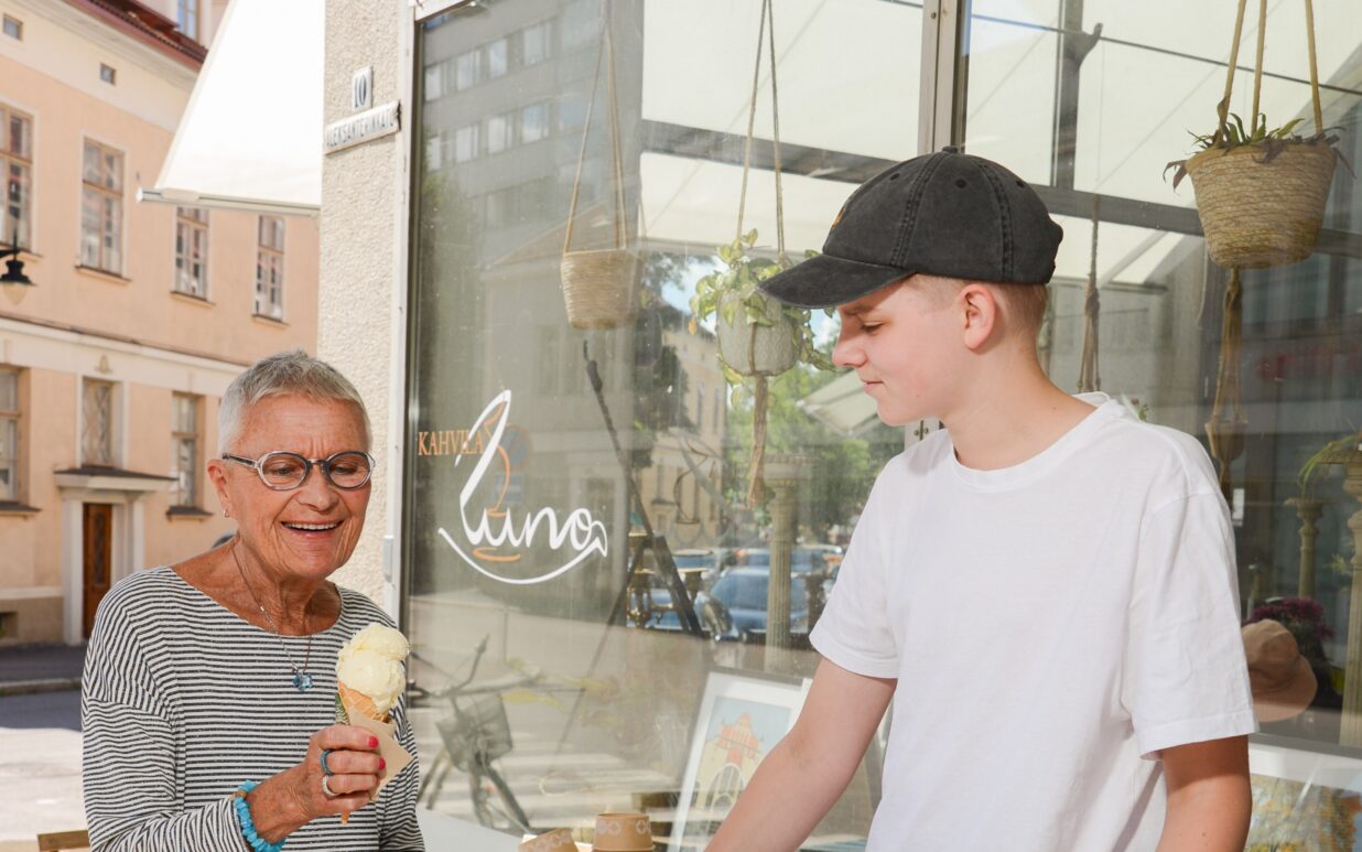 Kuvassa nuori poika myy jäätelöä vanhemmalle naiselle.